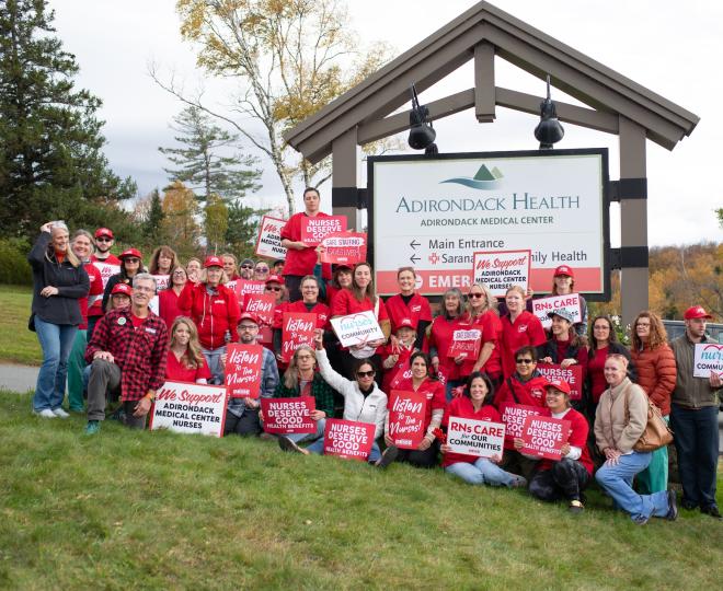 NYSNA nurses pose for a photo with signs
