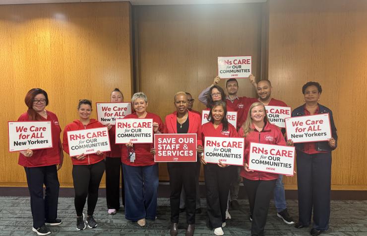 NYSNA nurses pose with signs before attending a PHHPC hearing