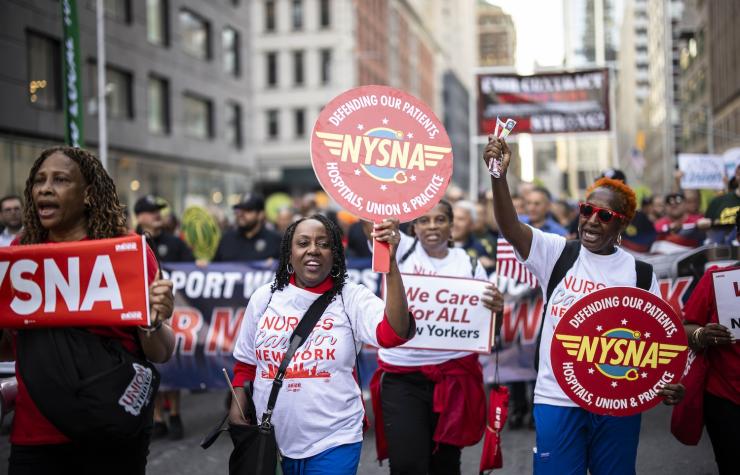 NYSNA nurses hold NYSNA signs while marching