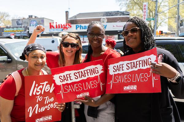 Members pose with safe staffing signs