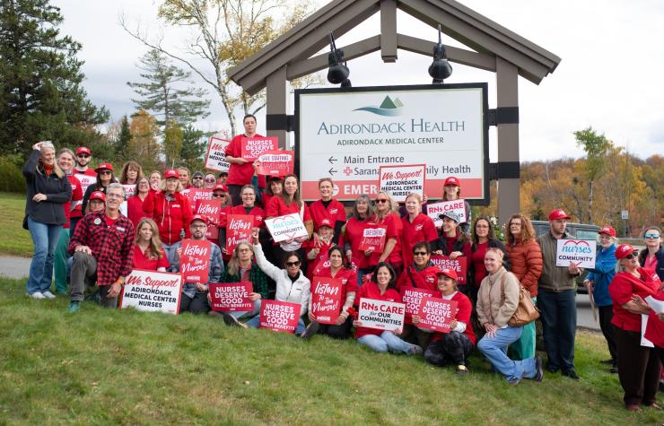 NYSNA nurses pose for a photo with signs