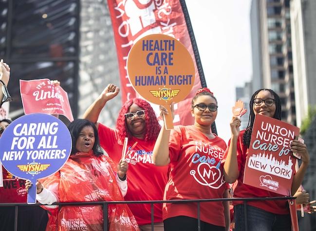 Nurses smiling on a float, celebrating Labor Day