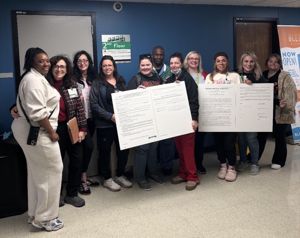 ECMC nurses deliver two big boards during a labor-management meeting