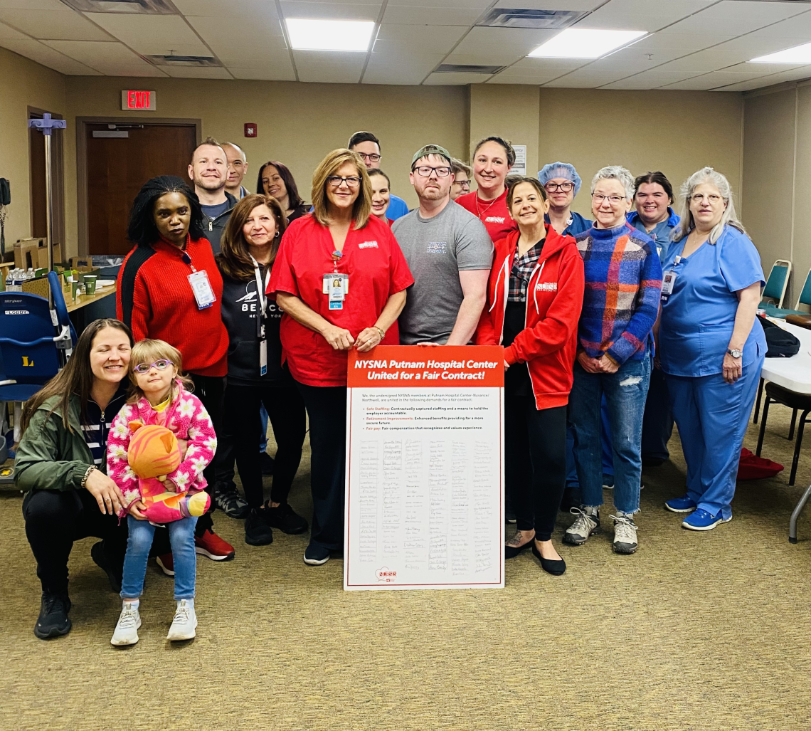 Nurses standing with large size print out of petition language and signatures