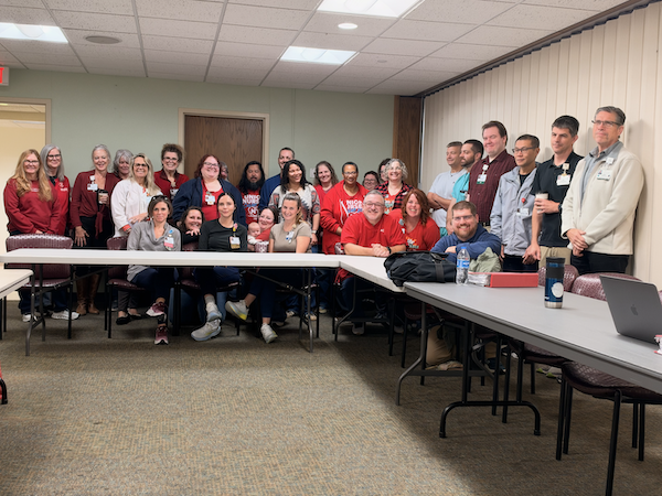 NYSNA members pose for a photo around the bargaining table 