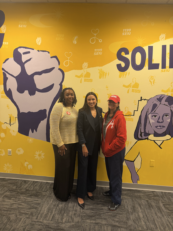 Two nurse leaders pose with U.S. Representative Alexandria Ocasio-Cortez
