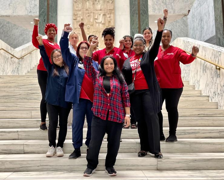 Nurses standing at the stairs in the NY Capitol Building with their fists up