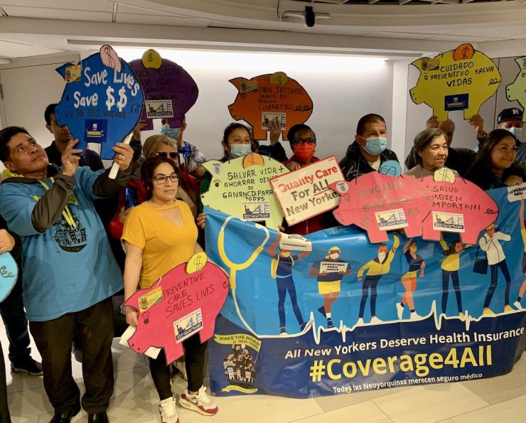 Advocates hold #Coverage4All signs