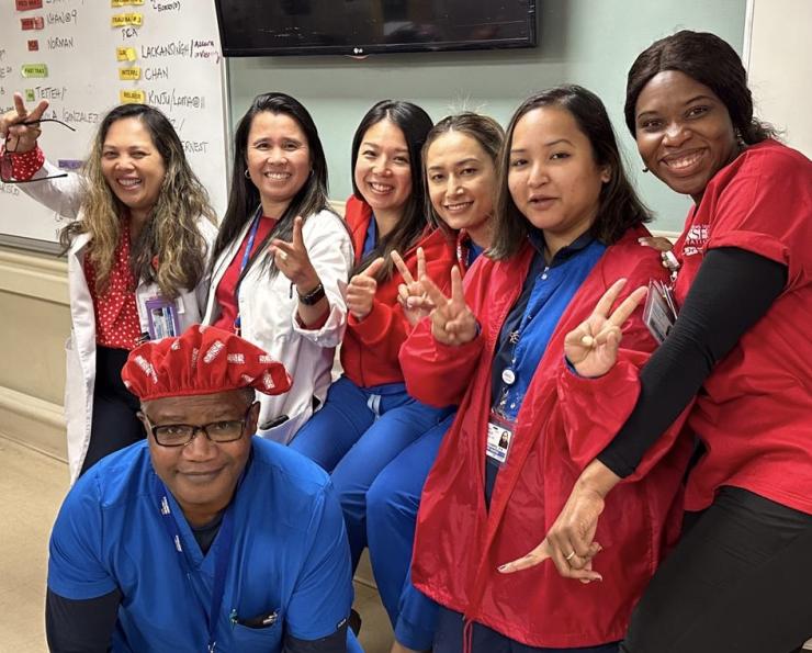 Lincoln Hospital nurses in scrubs smiling with peace hand signs
