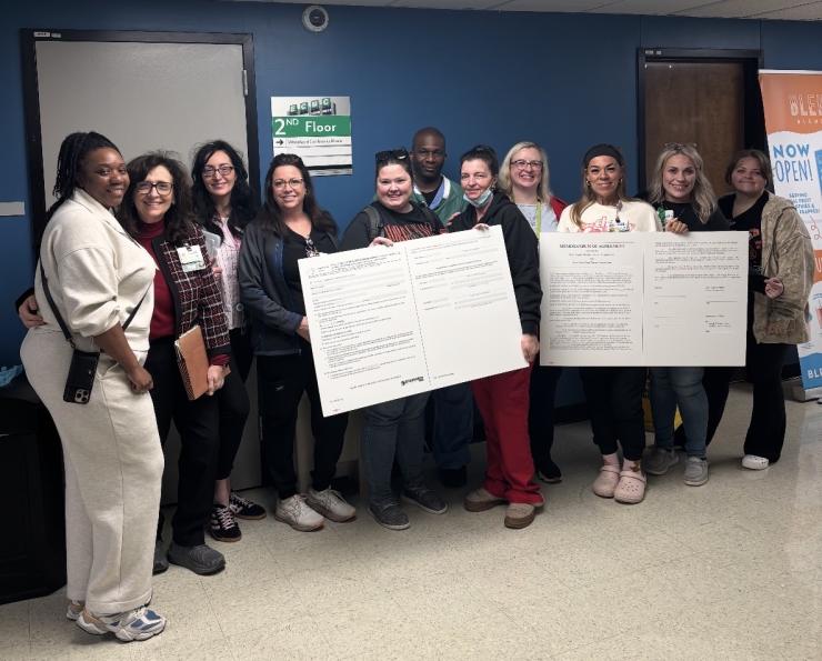 ECMC nurses deliver two big boards during a labor-management meeting