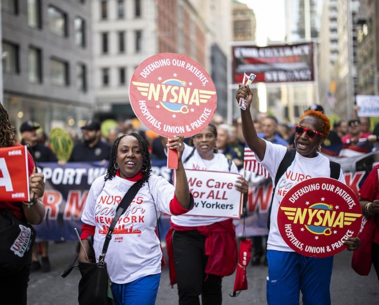 NYSNA nurses hold NYSNA signs while marching