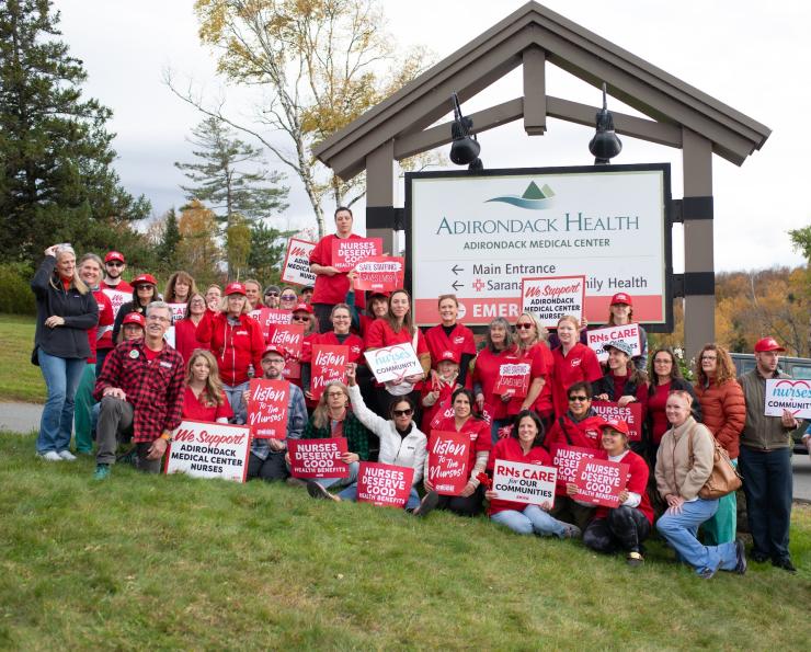 NYSNA nurses pose for a photo with signs