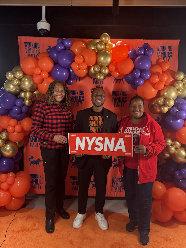 Two nurse leaders pose with a NYSNA sign and a Working Families Party Leader at the 2026 New York Working Families Party Convention