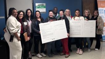 ECMC nurses deliver two big boards during a labor-management meeting