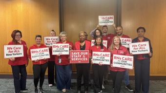 NYSNA nurses pose with signs before attending a PHHPC hearing