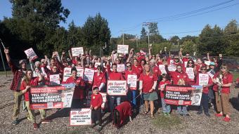 Adirondack Medical Center nurses pose with signs after re-hanging banners for a fair contract.