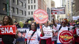 NYSNA nurses hold NYSNA signs while marching
