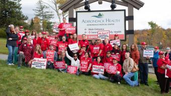 NYSNA nurses pose for a photo with signs