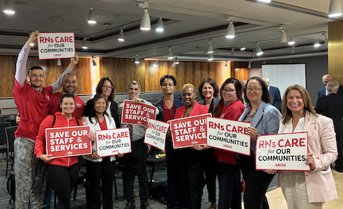 NYSNA members hold union signs at the PHHPC meeting. 