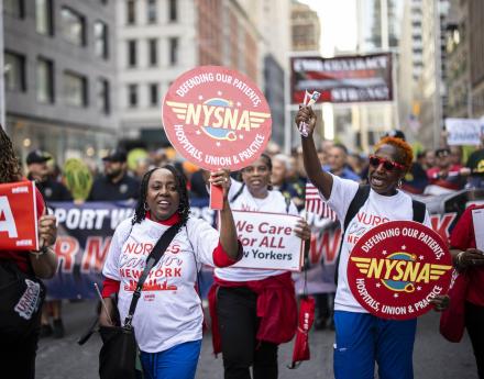 NYSNA nurses hold NYSNA signs while marching