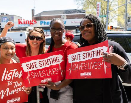 Members pose with safe staffing signs