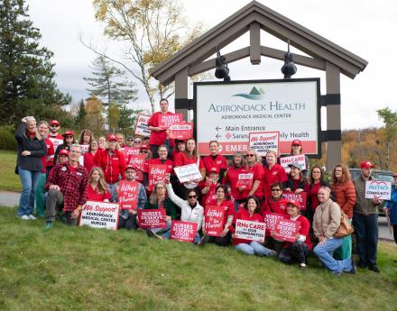 NYSNA nurses pose for a photo with signs
